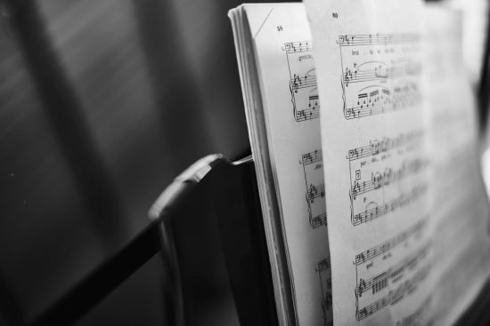 A black-and-white shot of an open music score on a stand. Original public domain image from Wikimedia Commons
